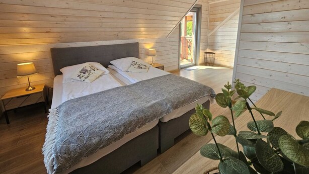 A bedroom with a bed, bedside tables, and a plant. - Comfortable Holiday Home With a Terrace and Garden (Karsin)