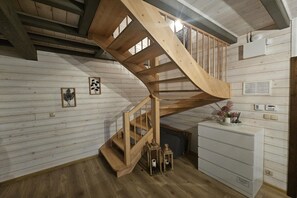 A wooden spiral staircase in a room with white wooden walls and a white cabinet. - Comfortable Holiday Home With a Terrace and Garden (Karsin)