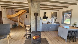 A modern kitchen with a stone wall, wooden staircase, and a built-in stove. - Comfortable Holiday Home With a Terrace and Garden (Karsin)