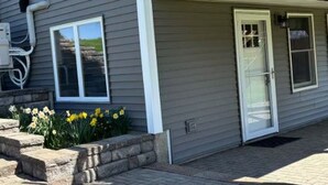 Une maison avec un porche couvert, une porte d’entrée et une fenêtre.