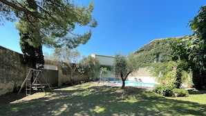 A backyard with a swimming pool, a swing set, and a stone wall. - 19th-century farmhouse combining authenticity and comfort (Gallargues-le-Montueux)