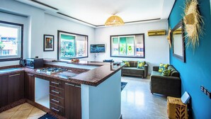 Una cucina moderna con isola centrale, elettrodomestici integrati e ampie finestre che garantiscono luce naturale.