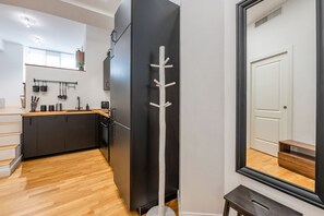 A modern kitchen with dark cabinets, a wooden floor, and a black refrigerator. - Prada's Nest - Modern design and close to metro (Milano)