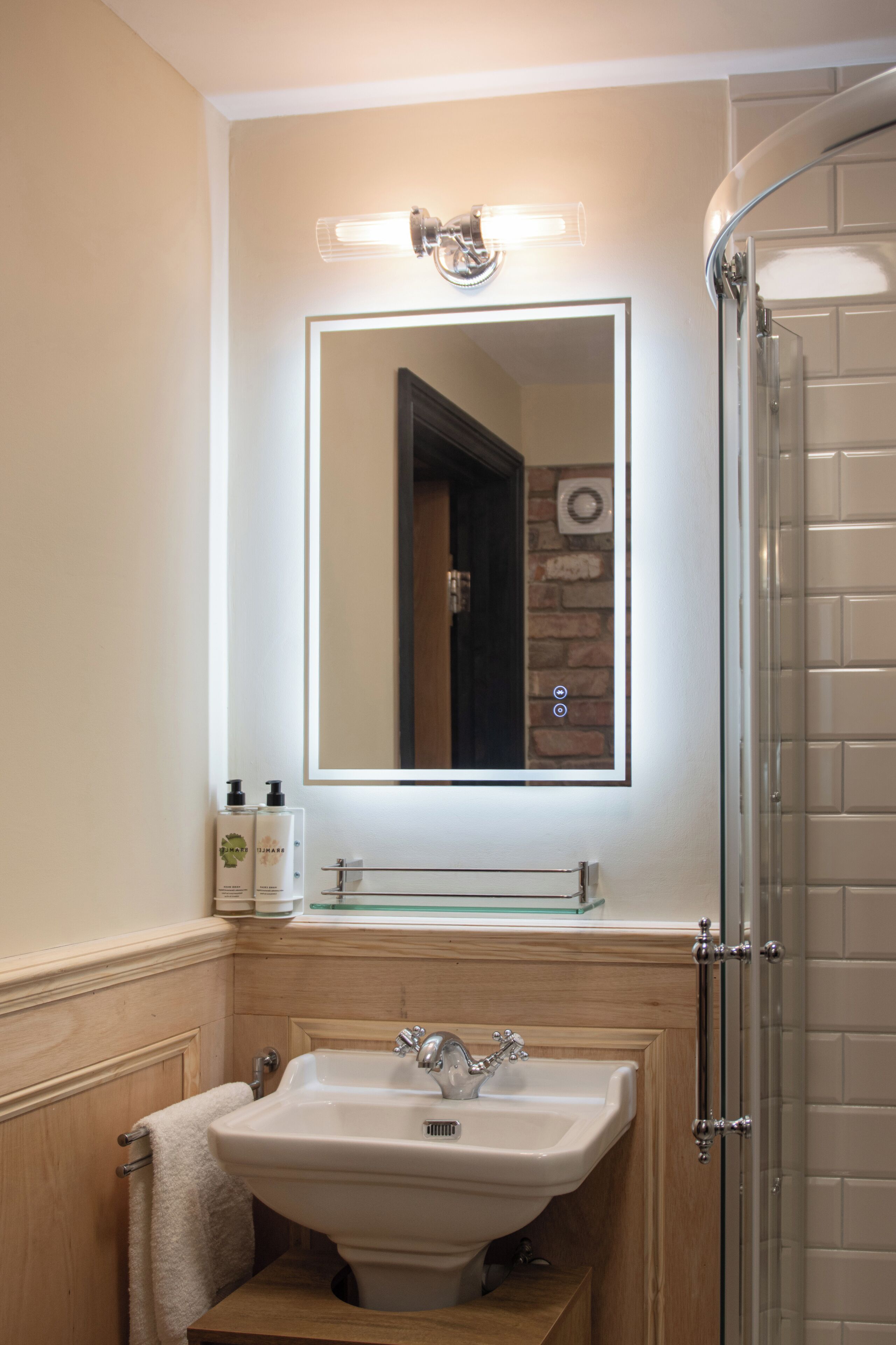 Une salle de bain avec un lavabo, un miroir et une douche.