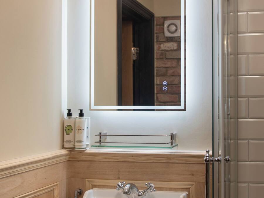 Une salle de bain avec un lavabo, un miroir et une douche.