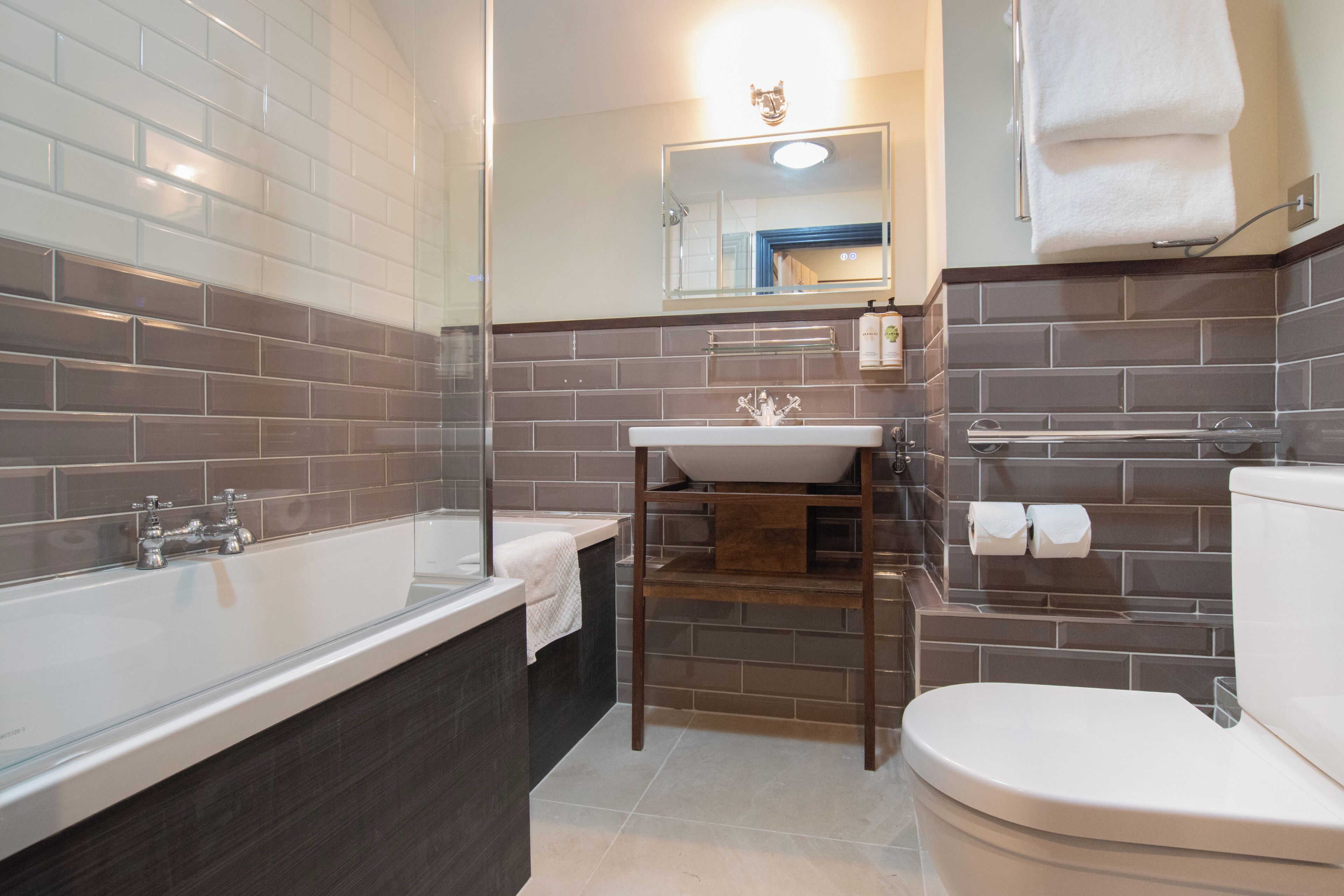 A modern bathroom with a bathtub, a sink, and a toilet.