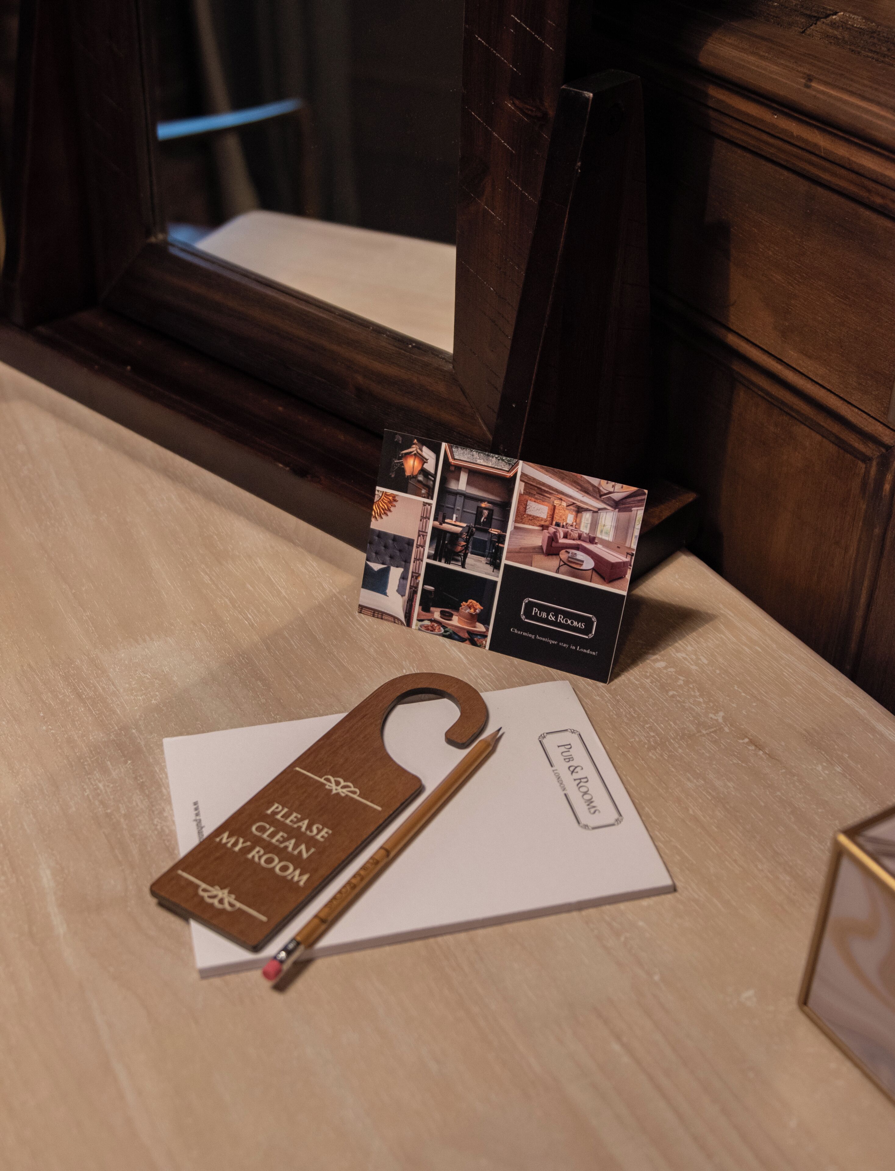 A wooden table with a keychain, a brochure, and a pen.