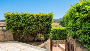 Une terrasse sur le toit, dotée d’un sol carrelé, de murs en pierre et d’une végétation luxuriante.