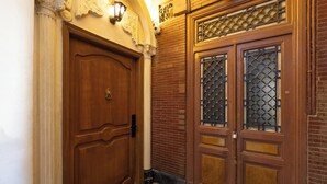 A wooden double door with a brass doorknob and a decorative glass panel. - Downtown Glass & Glory Heritage Stay (Cairo)