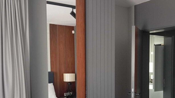 A hotel room with a bed, a bedside table with a lamp, and a wardrobe. - EBRU EVLERI ICMELER MERKEZE PLAJA YAKIN (Marmaris)