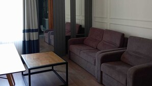 A living room with a sofa, a coffee table, and curtains. - EBRU EVLERI ICMELER MERKEZE PLAJA YAKIN (Marmaris)