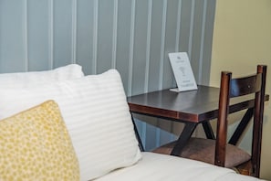 Ein Hotelzimmer mit einem Bett, einem Nachttisch aus Holz und einem Schild, das ein passwortgeschütztes WLAN anzeigt.