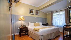 A bedroom with a large bed, a bedside table, a lamp, and a dresser. - Standard Room in Gigiri near UN Nairobi, Cozy Stead Garden House (Nairobi)