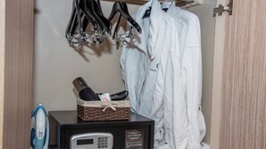 A hotel room with a minibar, an iron, a robe, and a hanging rack with towels. - Standard Room in Gigiri near UN Nairobi, Cozy Stead Garden House (Nairobi)