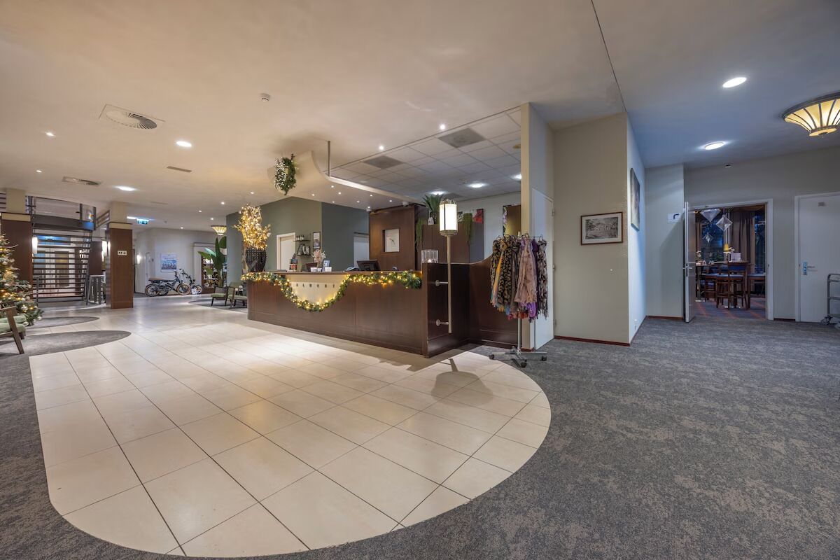 Ein Hotel-Empfangsbereich mit Theke, Sitzgelegenheiten und Teppichboden.