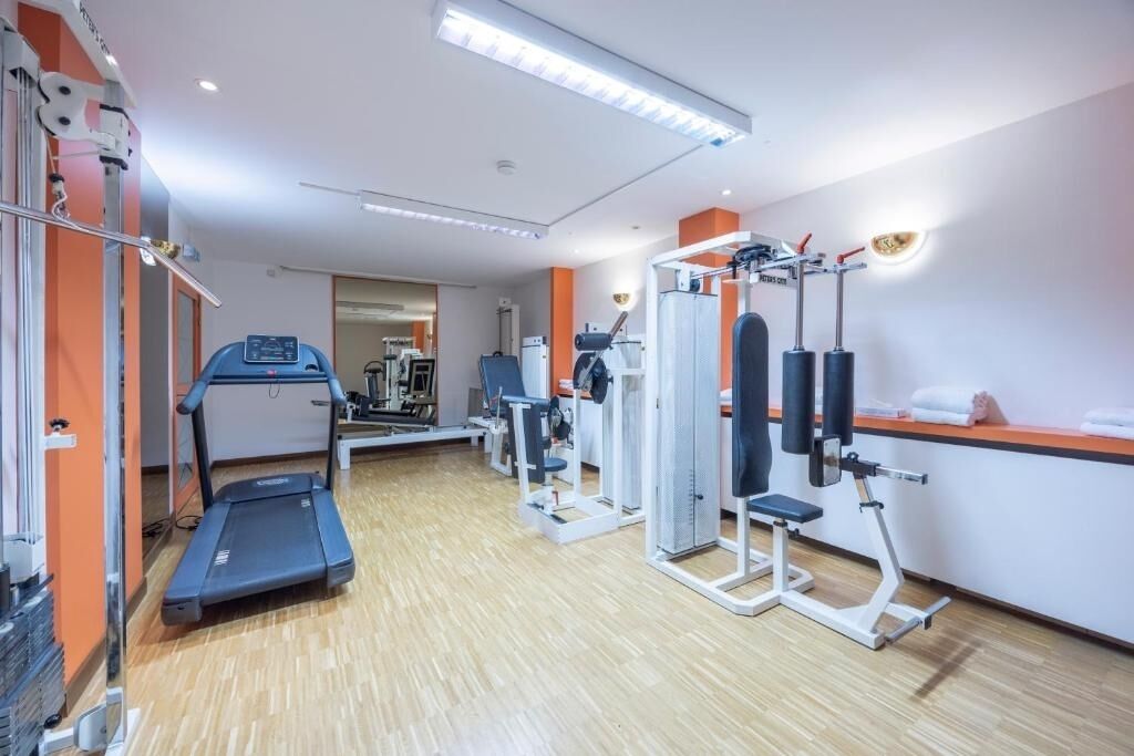 A gym with cardio equipment, weight machines, and a mirror.