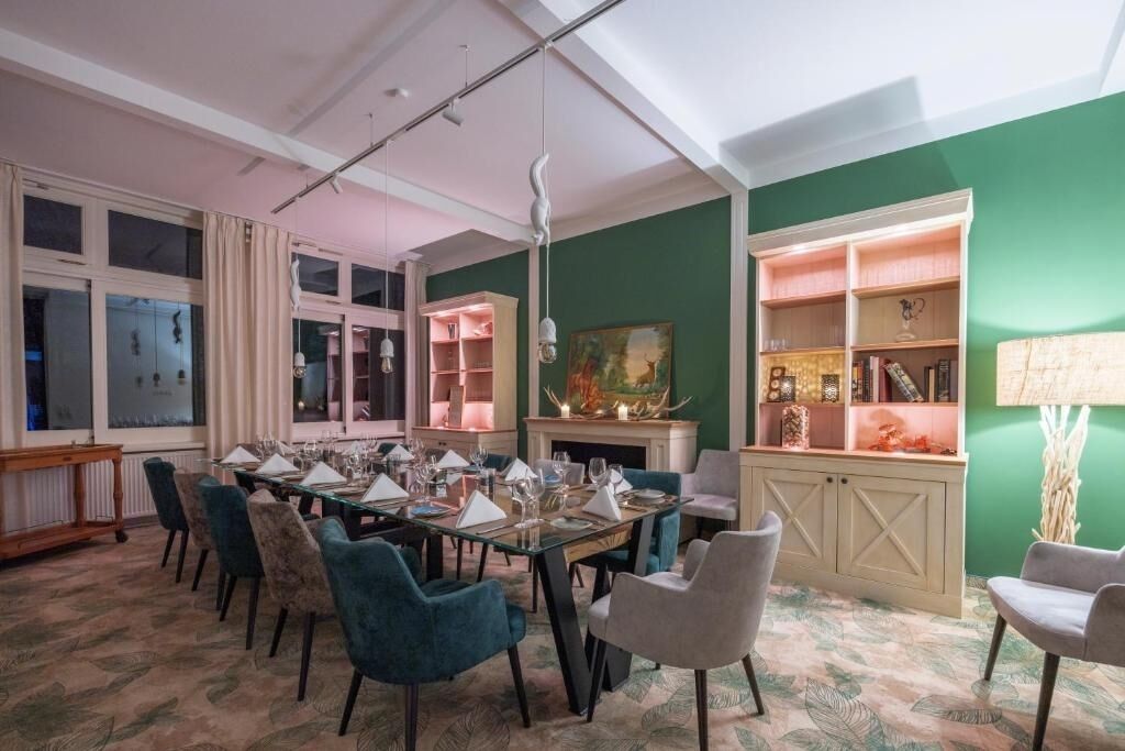 A dining area with a long table set for a meal, surrounded by chairs.