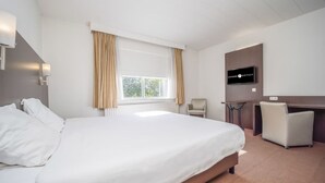 A hotel room with a large bed, a desk, a chair, and a television on the wall. - Refresh, Relax, Repeat: Your Comfortable Hideaway in Waalwijk (Waalwijk)