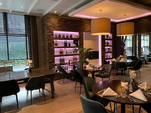 A restaurant with wooden floors, black chairs, and a bar area with shelves of bottles. - Rest & Recharge: Scenic Retreat Near Loonse and Drunense Duinen National Park (Waalwijk)