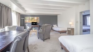 Una habitación de hotel con una cama grande, un escritorio, una silla, un sofá y un televisor.