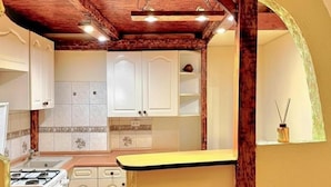 A compact kitchen with white cabinets, a wooden countertop, and a gas stove. - Charming studio with balcony near Ostrów Tumski Cathedral Island - Old Town in 15 min (Breslau)