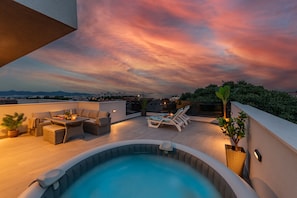 A rooftop terrace with a hot tub, lounge chairs, and a dining area. - Deluxe apartment Anelle with jacuzzi (Zadar)