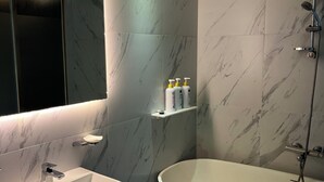 Un bagno moderno con una vasca freestanding, un lavandino e uno specchio.