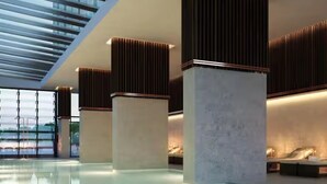 Ein moderner, überdachter Poolbereich mit Glasdecke und schlanken, minimalistischen Säulen.