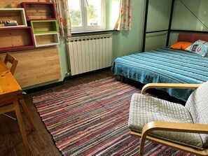 A room with a bed, a chair, a wooden desk, a radiator, and a window with curtains. - Km 54 – 1,200 m from the sea. Free parking. Expenses included. (Moneglia)