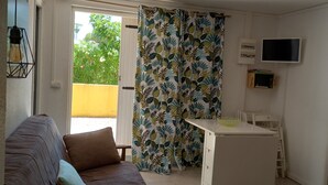 A modern living room with a sofa, a dining table, and a TV. - Cap d'Agde, Garden level Res. Agathe Plus, near Roquille and Mole beaches (Agde)
