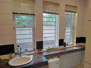 A bathroom with a sink, a toilet, and three windows with blinds. - Private 3-bedroom Family Villa in Siem Reap 2.8 Km to Angkor Wat Pet Friendly (Krong Siem Reap)