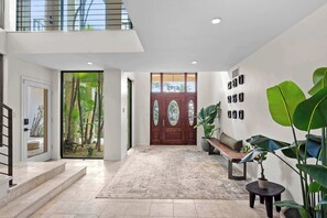 A modern interior with a wooden door, a bench, and a potted plant. - New! Lux Estate, Pool, Hot Tub, Sauna, Cold Plunge (Bradenton)