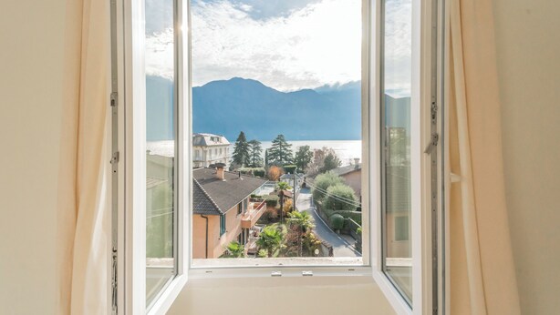 Ein Fenster mit Blick auf einen Berg und eine Stadt.