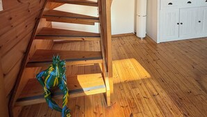 A wooden staircase in a room with a white cabinet and a flat-screen TV.