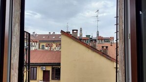 Une vue d’un bâtiment avec un toit recouvert de tuiles rouges et une façade jaune.