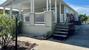 A single-story mobile home with a porch, a number '292' sign, and a small front yard. - Beachside Gem Steps from Intracoastal (St. Augustine)