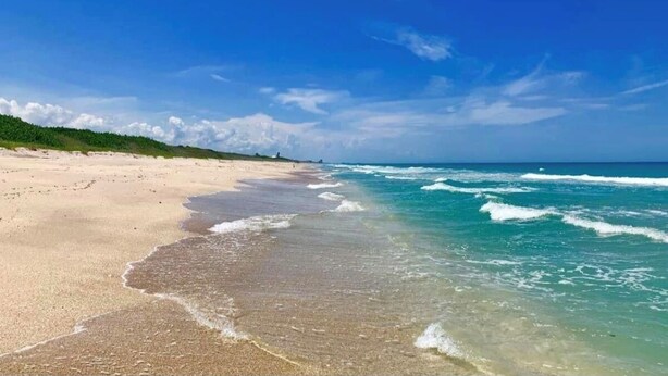 A beach with clear blue water, a sandy shore, and a distant horizon. - Beachside Gem Steps from Intracoastal (St. Augustine)