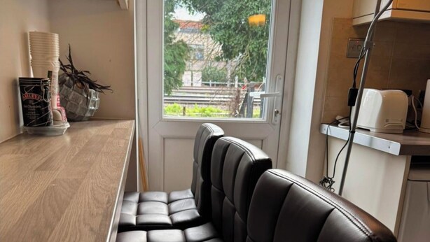 Un espace détente avec un comptoir en bois et une vue sur l’extérieur par une fenêtre.