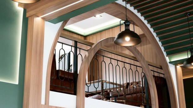 Un plafond en bois agrémenté de luminaires suspendus et un escalier doté d’une rampe en métal.