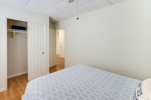 Ein Schlafzimmer mit Bett, Schrank und einem Flur, der in einen anderen Raum führt.