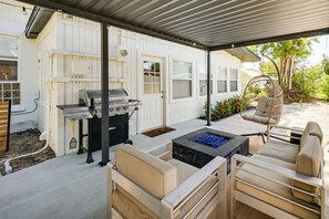 A covered outdoor patio with a grill, seating area, and a fire feature. - Legacy Trail Retreat  Bikes, Peloton + Fire Pit (Sarasota)