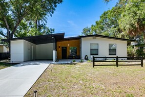 Ein zweistöckiges Haus mit Garage, überdachter Auffahrt und umzäunter Garten.