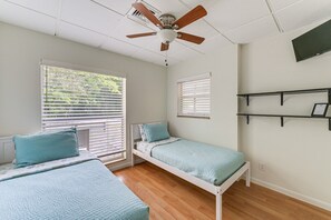 A bedroom with two beds, a ceiling fan, and a window with blinds. - Legacy Trail Retreat  Bikes, Peloton + Fire Pit (Sarasota)