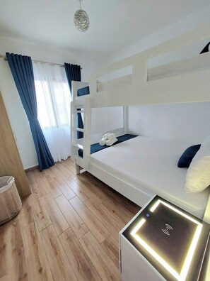 Ein Mehrbettzimmer mit Nachttisch und Lampe.