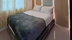 A modern bedroom with a bed, curtains, an air conditioning unit, and a unique ceiling light fixture. - Casa De Amor Villa 1338 - Panglao (Dauis)
