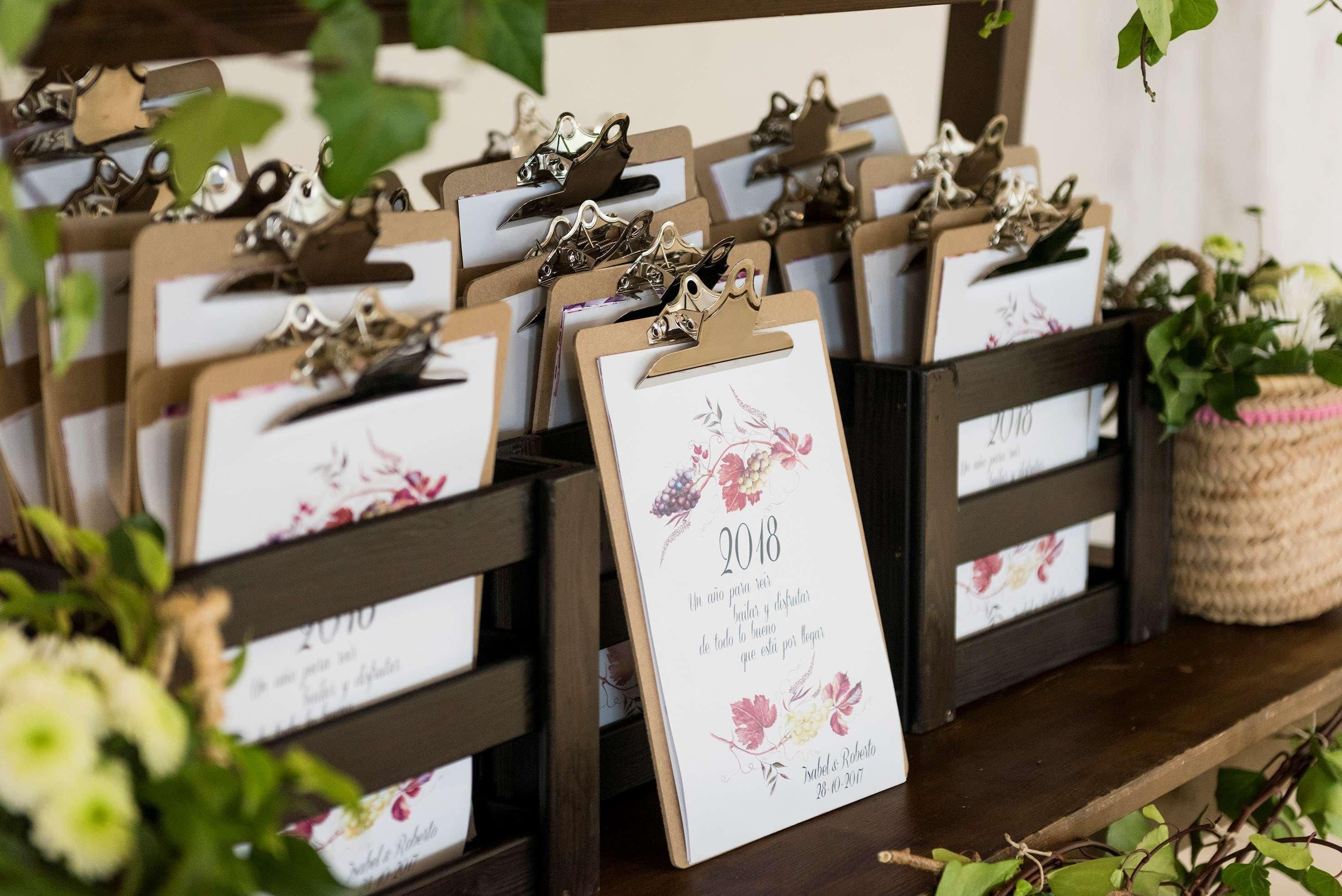 Una estantería de madera con varios portatarjetas, cada uno mostrando una tarjeta con un diseño floral y un año impreso.