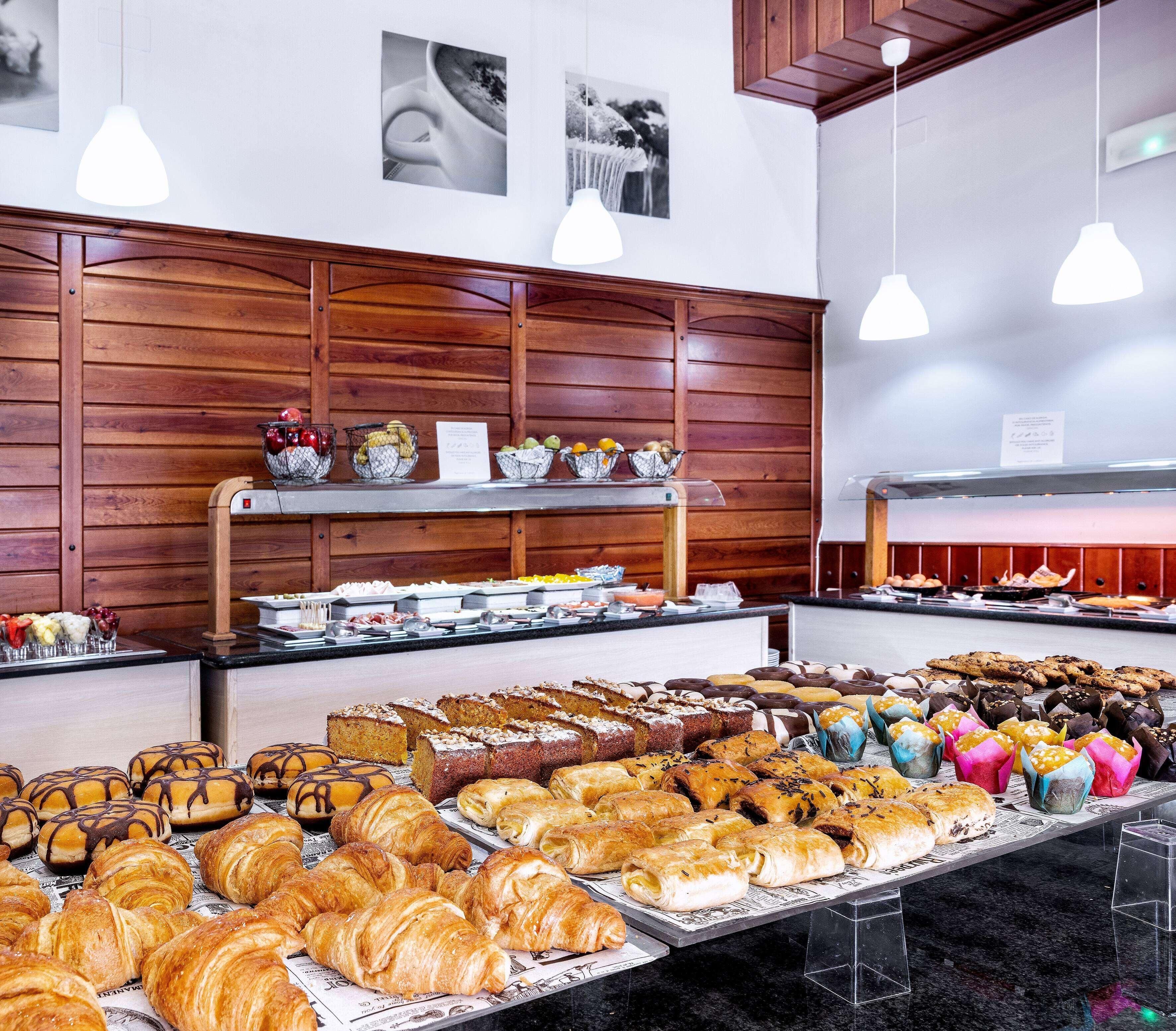 Mostrador de panadería con diversos productos horneados y un bol de fruta.