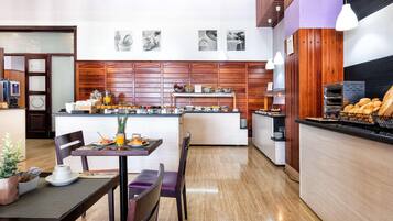 Una cocina moderna con una isla central, paneles de madera y una barra de desayuno.