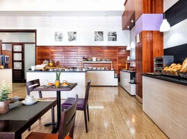 Una cocina moderna con una isla central, paneles de madera y una barra de desayuno.