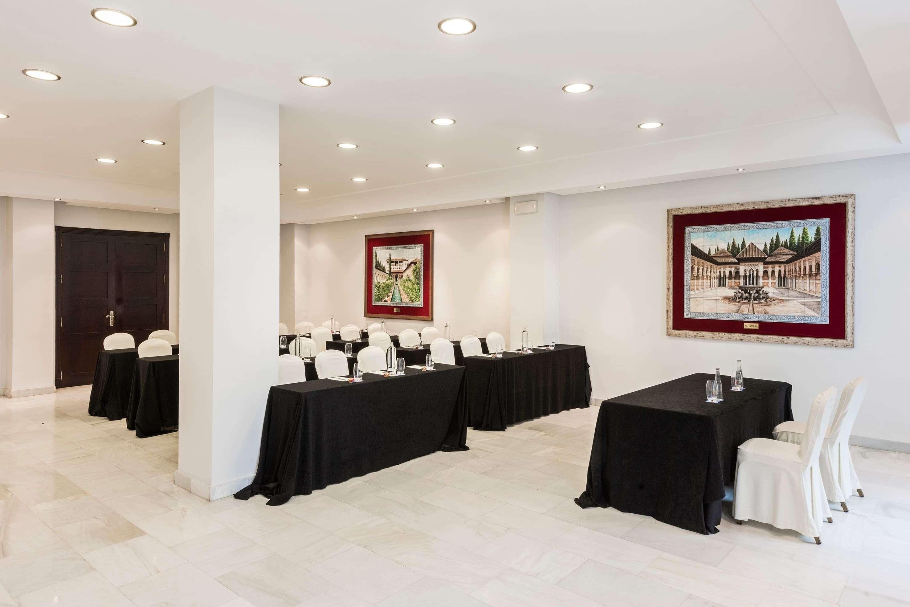 A conference room with tables, chairs, and artwork on the walls.